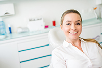 A smiling female patient in the dental chair at the office of Roy C. Blake III, DDS, MSD, Maxillofacial Prosthodontist in Jupiter Florida.